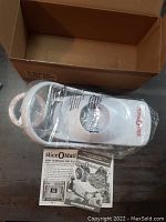 Unopened Slice-O-Matic vegetable slicer in original packaging with instruction manual visible.