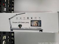 Box showing lamp image, features, and brand name Ouryes LED Desk Lamp.
