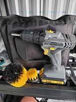 Topelek 20V cordless drill with three cleaning brush attachments and carrying bag shown.