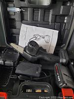 Photo showing the 24V cordless chainsaw, battery, charger, user manual, and molded carrying case