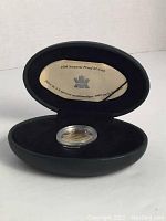 1999 Nunavut $2 silver coin displayed inside the open black oval presentation case with included documentation visible