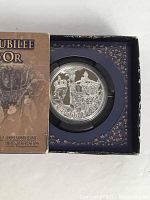 Top view of the reverse of the silver coin showing the Golden Jubilee commemorative design with intricate details and labeled 'Golden Jubilee 1952-2002'. Coin housed in a protective capsule set inside a decorative original box.