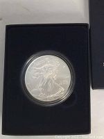 Obverse side of the 2008 American Silver Eagle coin showing the Walking Liberty design with the date 2008, inside protective capsule in display box.
