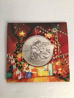 2013 Royal Canadian Mint $20 silver coin displayed on original Christmas-themed card with festive designs including presents and candy canes.