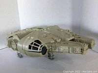 Side front angle view of the Millennium Falcon toy showing detailed paneling, cockpit, and landing gear extended.