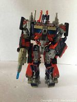 Front view of the Optimus Prime figure showing color, details, and blaster accessory.