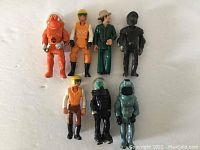 Front view of seven vintage Fisher Price Adventure People figures showing colors and apparel details.