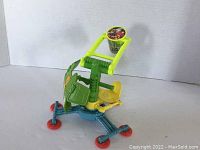 Side view showing the seat, back panel with TMNT logo, and the arm with bucket of the catapult toy.