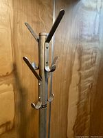 Close-up of upper section metal hooks and central pole with visible manufacturer label.