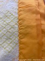 Close-up of yellow satin poly trim stitching and fleece fabric