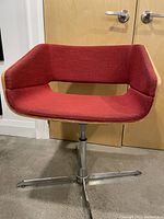 Front view of ruby red fabric swivel chair with wood wrap sides and cut-out backrest.