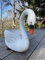 Side view of vintage white blow mold swan planter with orange and black beak, detailed feather texture.