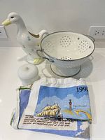 All items together including hand painted duck pitcher, Hazel Atlas container, enamel colander, and two linen towels
