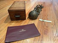 Full lot showing oak card file, brass lamp, slide ruler and burgundy cheque book holder on a wood floor