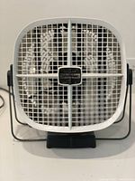 Front view showing white plastic fan with grille and control switch