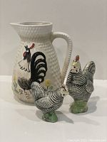 Photo of three-piece set showing white hobnail ceramic jug/vase decorated with rooster and two chicken-shaped salt and pepper shakers.