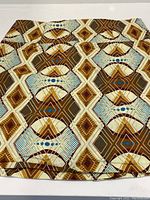 Close-up photo of the fabric pattern emphasizing colors and geometric shapes.