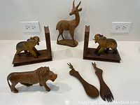 Photo showing all items: antelope figurine, elephant bookends, lion figurine, and two utensils