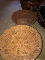 Five woven wicker baskets in various sizes and colors, including a light natural basket and darker baskets