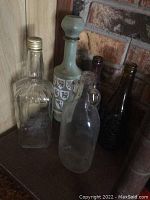 Clear and amber glass bottles with one frosted decorative bottle in corner