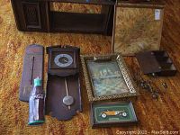 Wooden pendulum wall clock, Coca Cola bottle thermometer, rusty Pepsi metal thermometer, framed Last Supper, bird-themed framed art, pair of metal wall sconces, mini wooden wall cabinet on carpet