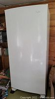 Front view of closed white upright freezer