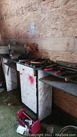 Workbench with assorted hand tools including hammers, handsaws, and a level, some tools wooden-handled, others metal.