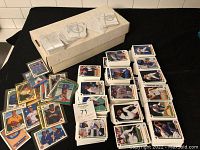 Several stacks of 1991 Upper Deck baseball cards displayed with a white storage box beneath, cards are in sleeves and loose.
