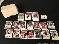 Photo showing large quantity of stacked and loose 1992 O-Pee-Chee Premier hockey cards along with box and card sleeve labeled 74