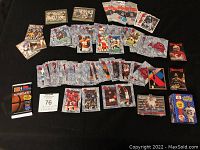 Wide shot of most cards in lot showing packs and loose cards on black surface.