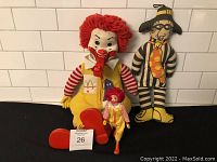 Three McDonald character dolls together: large Ronald McDonald, smaller Ronald McDonald, and Hamburglar