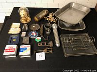 Lot overview showing kitchen trays, tins, metal tools, flashlight, and other collectibles
