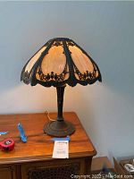 Full view of the Miller Light Company Art Nouveau style table lamp on a wooden surface, showing the lamp and base.