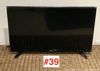 Front view of Toshiba flat screen TV showing screen and stands.