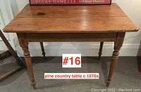 Front view of pine table showing full top and legs under framed artwork