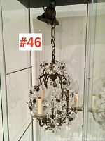 Front view showing crystal flower accents, metal frame, and two candle socket arms.