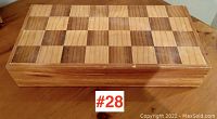 Closed wooden folding chess/checkers board showing the checkerboard pattern on the top surface.