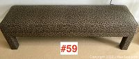 Top-down view of the rectangular leopard print upholstered bench showing the full surface and front legs.