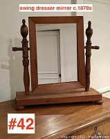 Front view of Victorian wooden swing dresser mirror circa 1870s on wooden base with finials and horizontal pegs for mirror pivot.