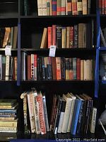 Photo of several shelves filled with hardcover and paperback books focused on ceramics, art, and history.