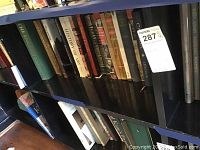 Shelf with assorted books on art and history. Titles include 'History of Art', 'The English', and others.