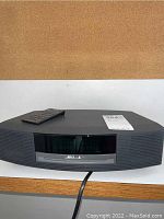 Front view of Bose Wave Music System III main unit with remote control placed on top