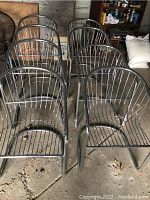 Front view of eight chrome metal wire chair frames in garage
