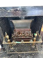 Front view of decorative fireplace screen and hearth with faux coals in fireplace.