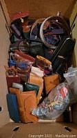 Top-down view of entire lot showing leather cases, eyeglasses, suspenders and bag of keychains