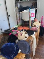 Overview of assorted hats, parasols and back scratchers arranged on wooden surface