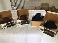 Four hats displayed in Stetson boxes on bed