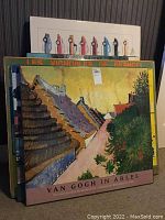 Photo of a stack of large posters including Van Gogh art and French wine regions maps.