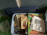 Top view of plastic bin containing various packaged doll house furniture items including Chrysbon packaging.