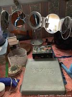 Five round electric light-up makeup mirrors, various other items including shell box, wood lazy Susan, painted music jewelry box on the table surface